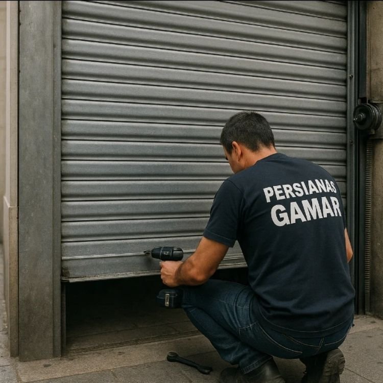 Técnico instalando persianas metálicas para comercios en Barcelona